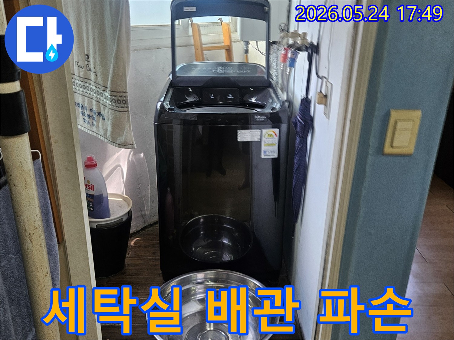 세탁기 옆에-놓인 양동이로-물이 새는-현장을 임시 조치한-사진