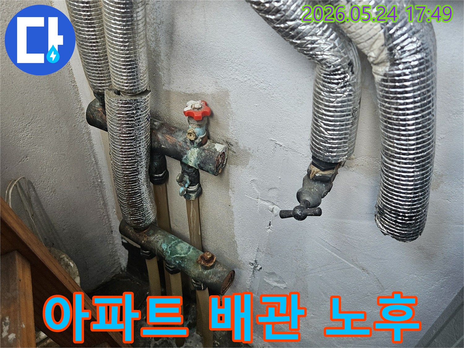 오래된 아파트의 노후된 배관에서 발생한 누수-벽면의 물자국과 부식된 배관이 보입니다