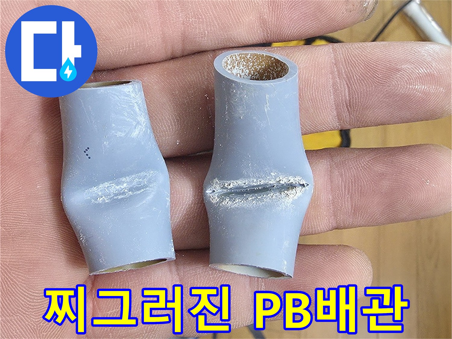 손가락 사이에 끼워진 함몰된 모양의 회색 배관