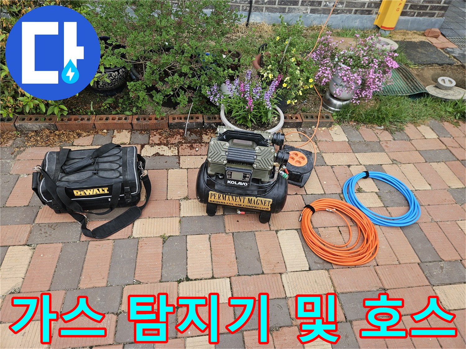 바닥에 놓인 가스식 누출 탐지기와 주황색 에어 호스