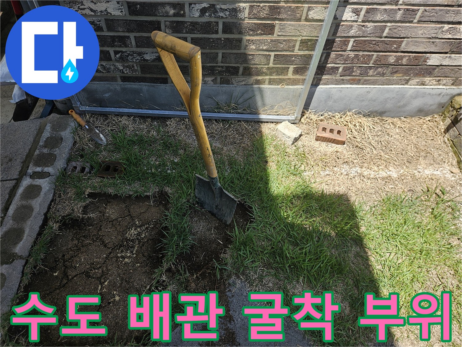 삽을 이용해-외부 수도 배관의 누설 지점을 찾기 위해 땅을 파낸 장면입니다.