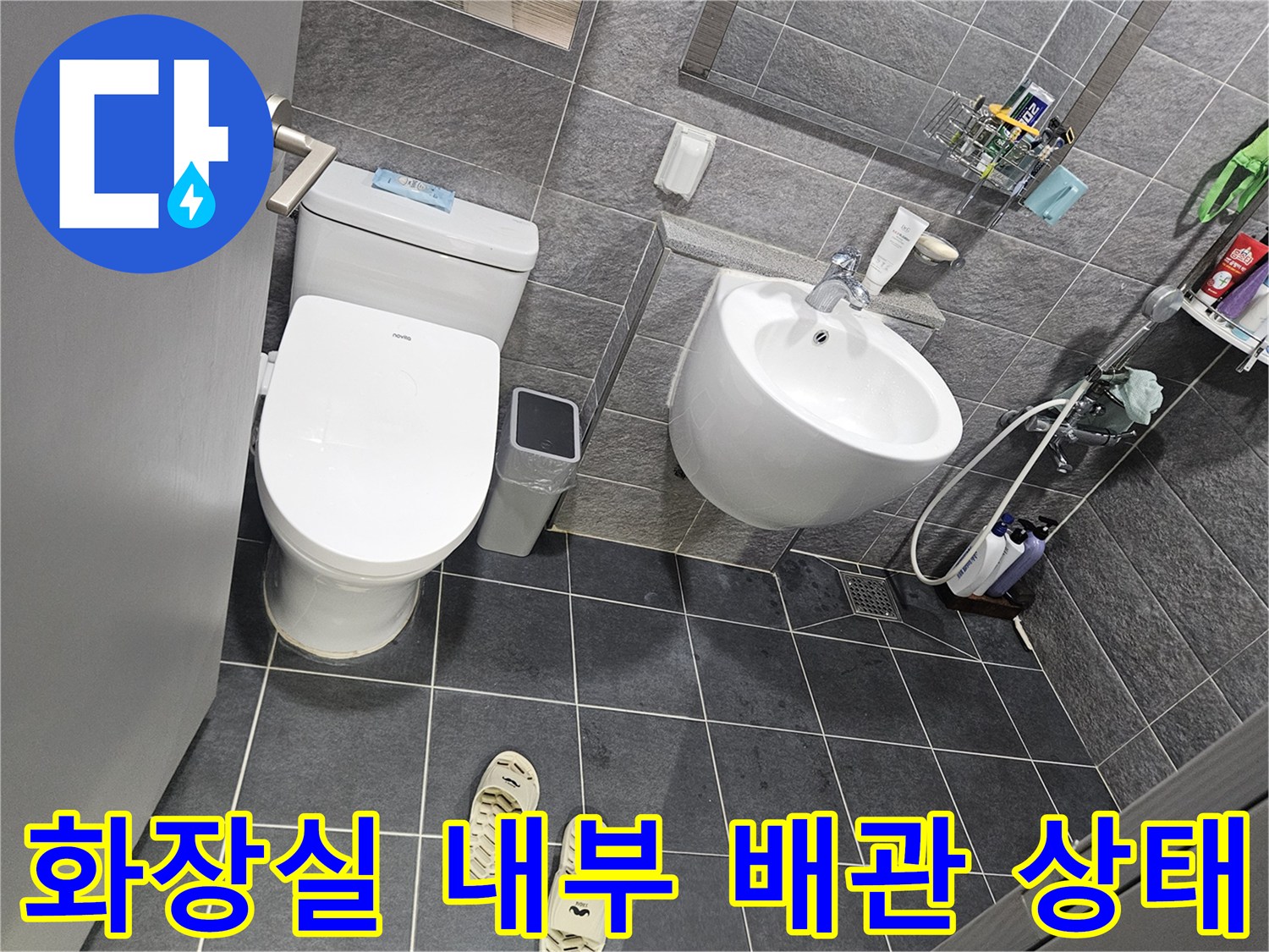 세면대 하부 수전과 변기 주변의 배관 시설물 사진입니다.