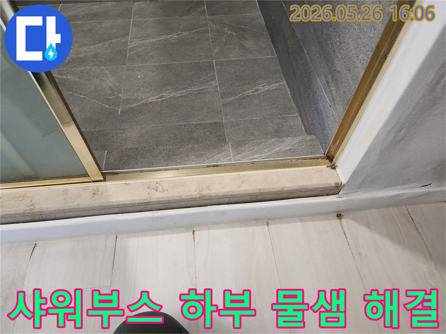 욕실-샤워부스-하부에서-물이-새어-나와-바닥에-손상을-주고-있는-누수-현장-사진