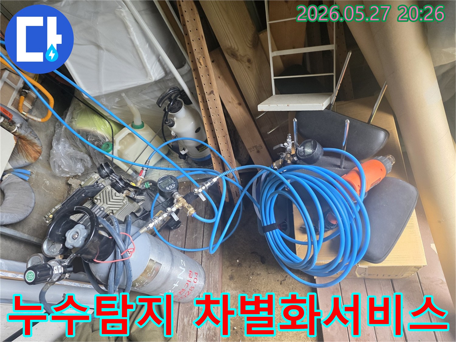 누수 탐지 전문 업체의 차별화된 서비스를 보여주는 장비들로-압력 조절기와 가스 실린더-그리고 파란색 호스들이 현장에 준비된 모습입니다.