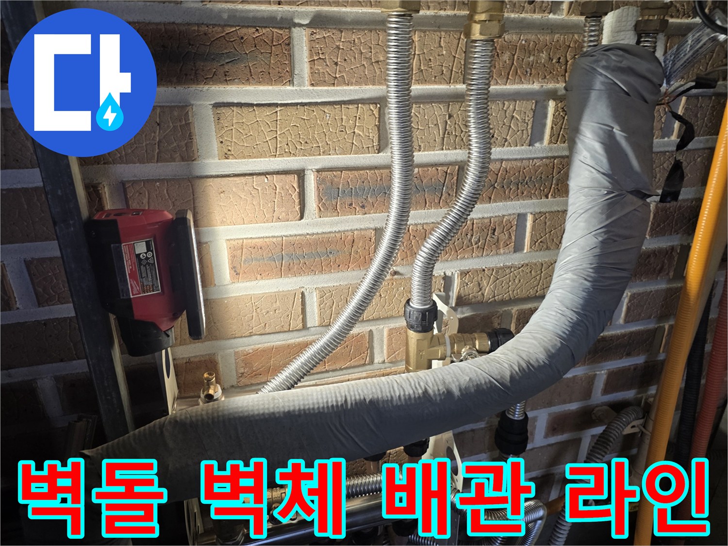벽돌 벽면에 복잡하게 연결된 수도 배관 및 측정 장비 일부