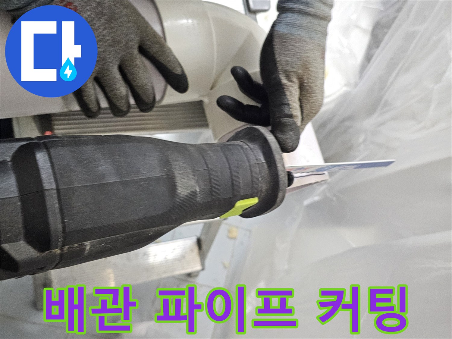 작업자가 장갑을 끼고 전동 공구로 배관을 절단하는 근접 사진