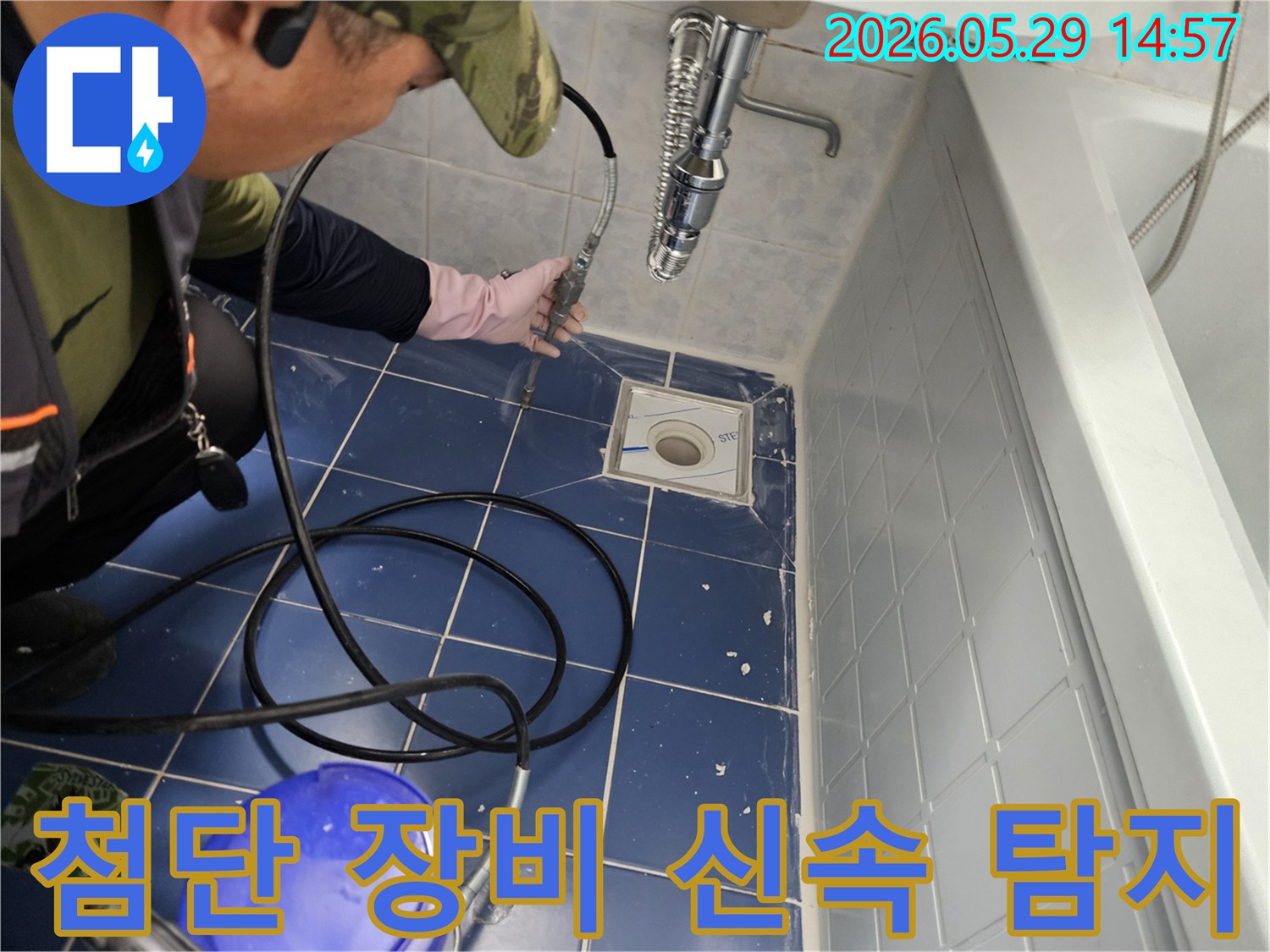 누수 전문 엔지니어가 욕실 바닥 배수구에 첨단 장비를 삽입하여 배관 내부를 신속하고 정밀하게 탐지하는 모습입니다-최신 기술로 빠른 문제 해결을 돕습니다