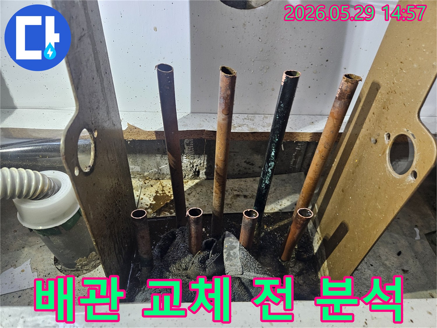동두천 생연주공아파트 누수 현장에서-바닥을 개방하고 노출된 배관의 교체 전 상태를 정밀하게 분석하는 전문가의 모습