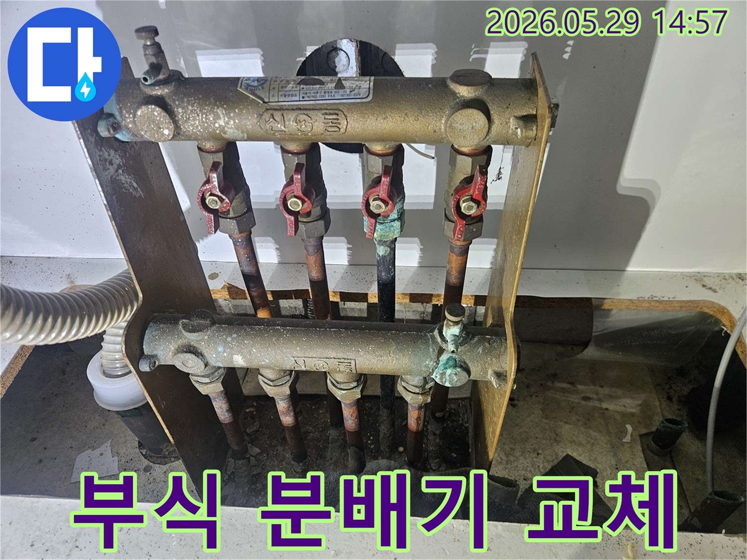 오래된 아파트의 난방 분배기에서-심각한 부식과 함께 누수 흔적이 발견되어-전문가가 교체 작업을 준비하고 있습니다.
