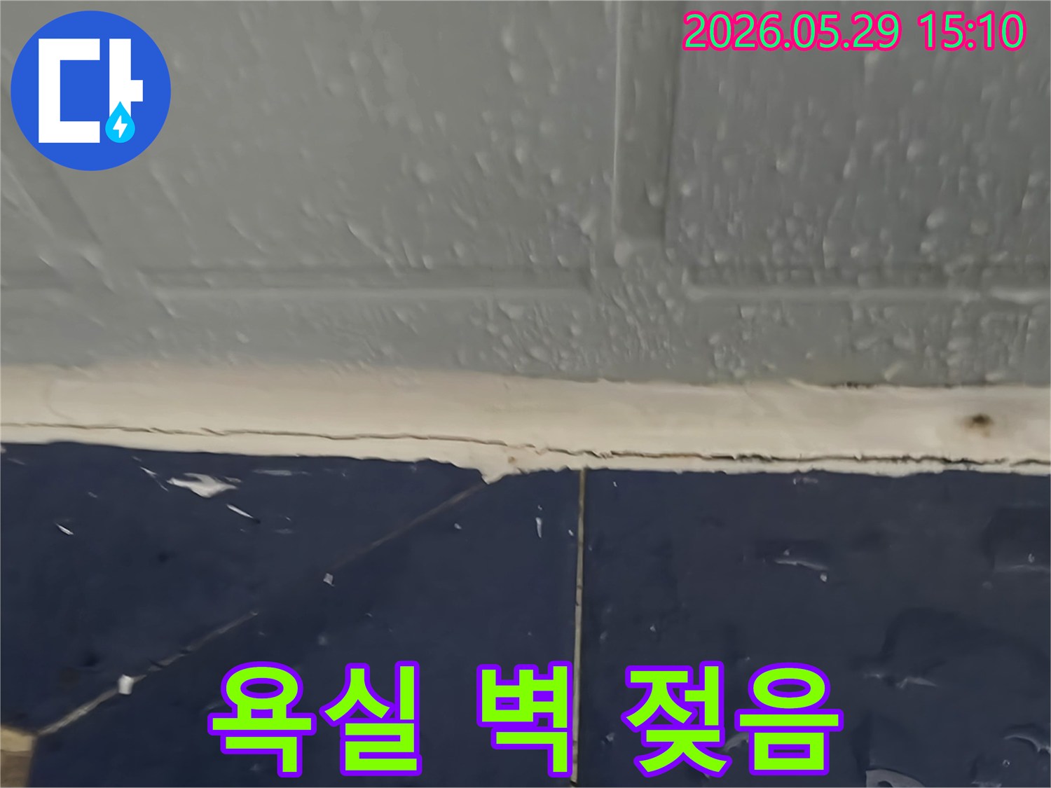 욕실 벽면-타일 이음새를 따라 물이 스며들어 젖어있는 모습-누수 전문가가 공사를 준비 중