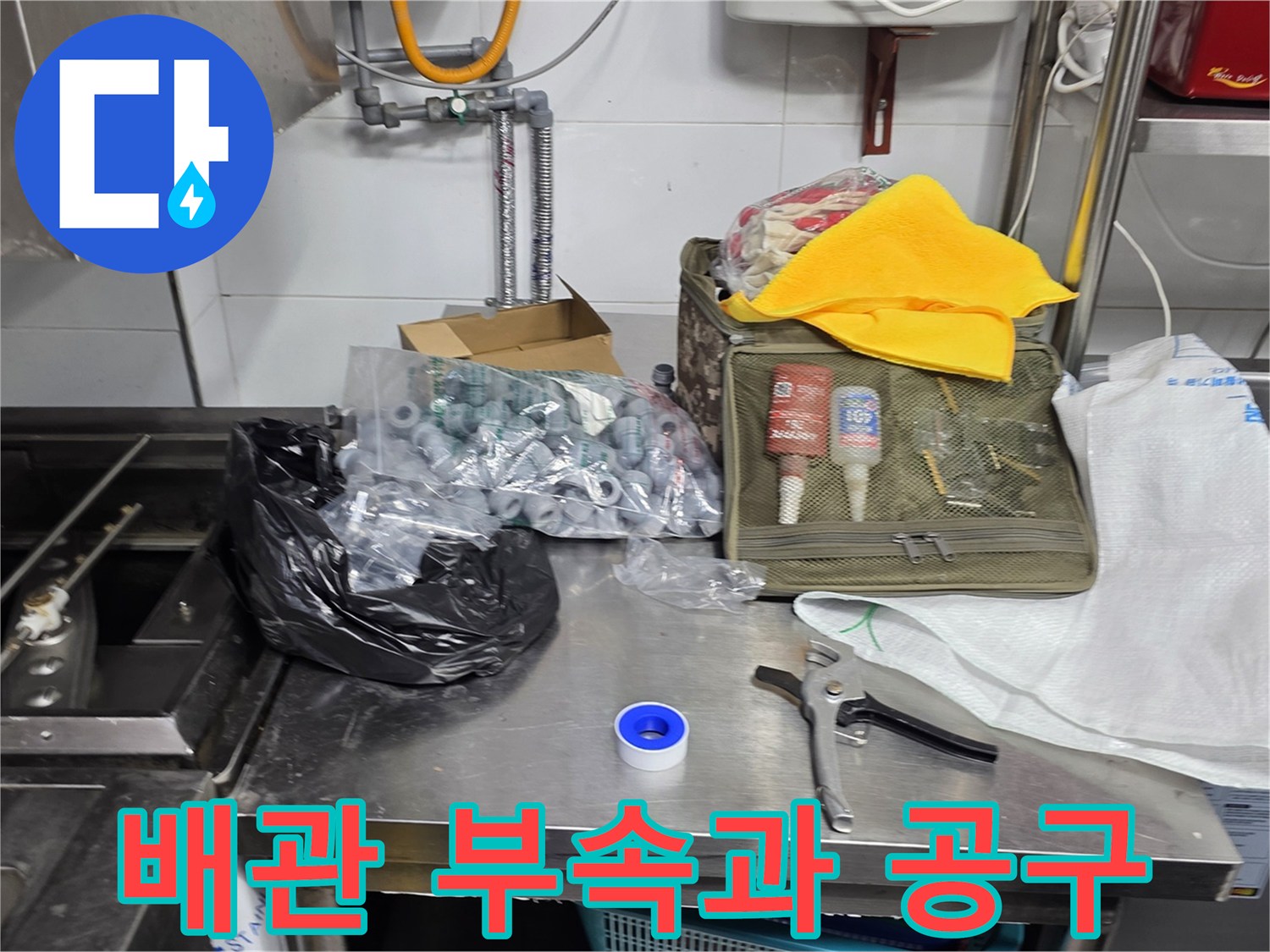 식당 주방 공사를 위해 준비된 배관 부품과 펜치