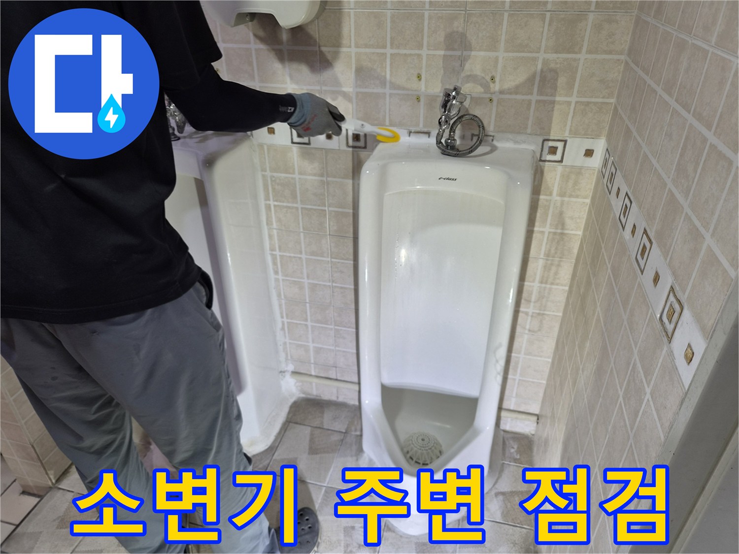 사무실 화장실 소변기 뒤쪽 급수 밸브와 타일 부위 점검 중인 모습