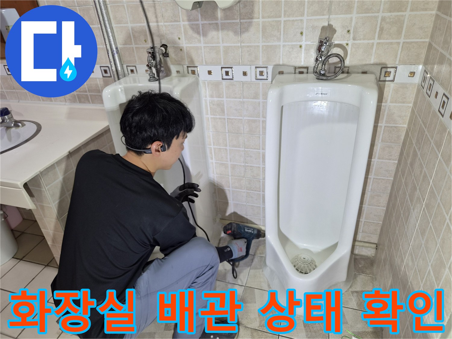 소변기 뒤쪽과 아래쪽의 배관 연결 상태를 점검하는 작업 모습입니다.