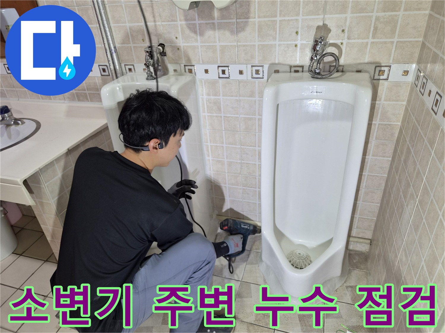 소변기 하단 배관의 상태를 자세히 관찰하며 작업을 이어가는 모습입니다.
