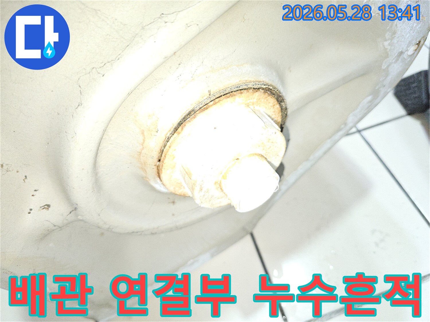 이 사진은 오래된 배관 연결부에서 발생한 누수 흔적을-자세히 보여줍니다