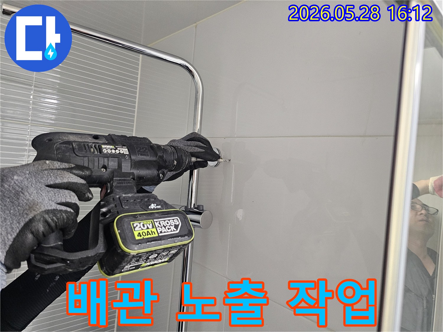 숙련된-기술자가-욕실-타일-벽에-드릴로-작업하여-배관을-노출시키는-모습입니다.
