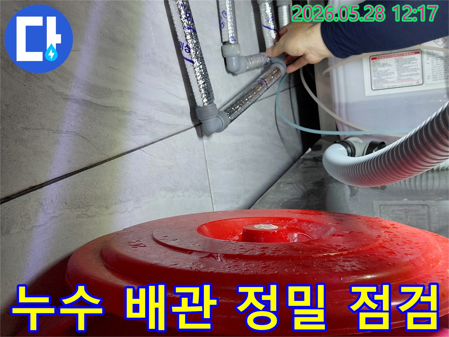 숙련된 엔지니어가-젖은 바닥과-연결된 배관들을-정밀하게 점검하여-누수 지점을-찾아내고 있습니다.