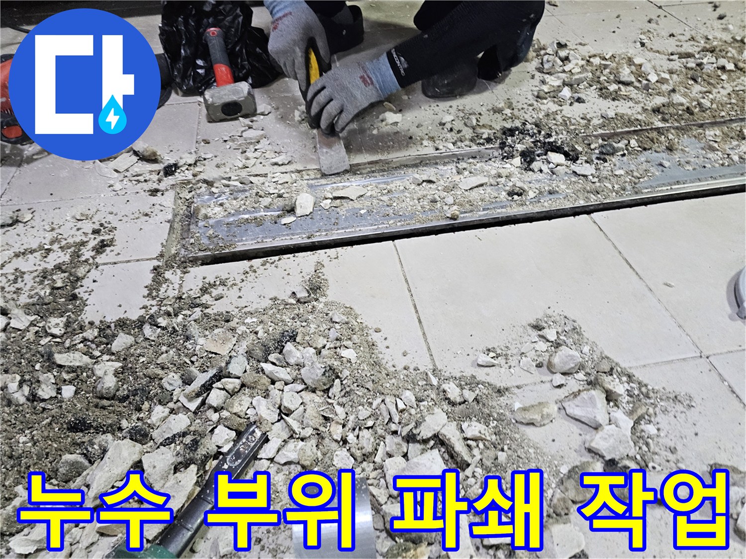 공사 장비를 사용하여 트렌치 인근의 타일을 걷어내는 현장 사진입니다.