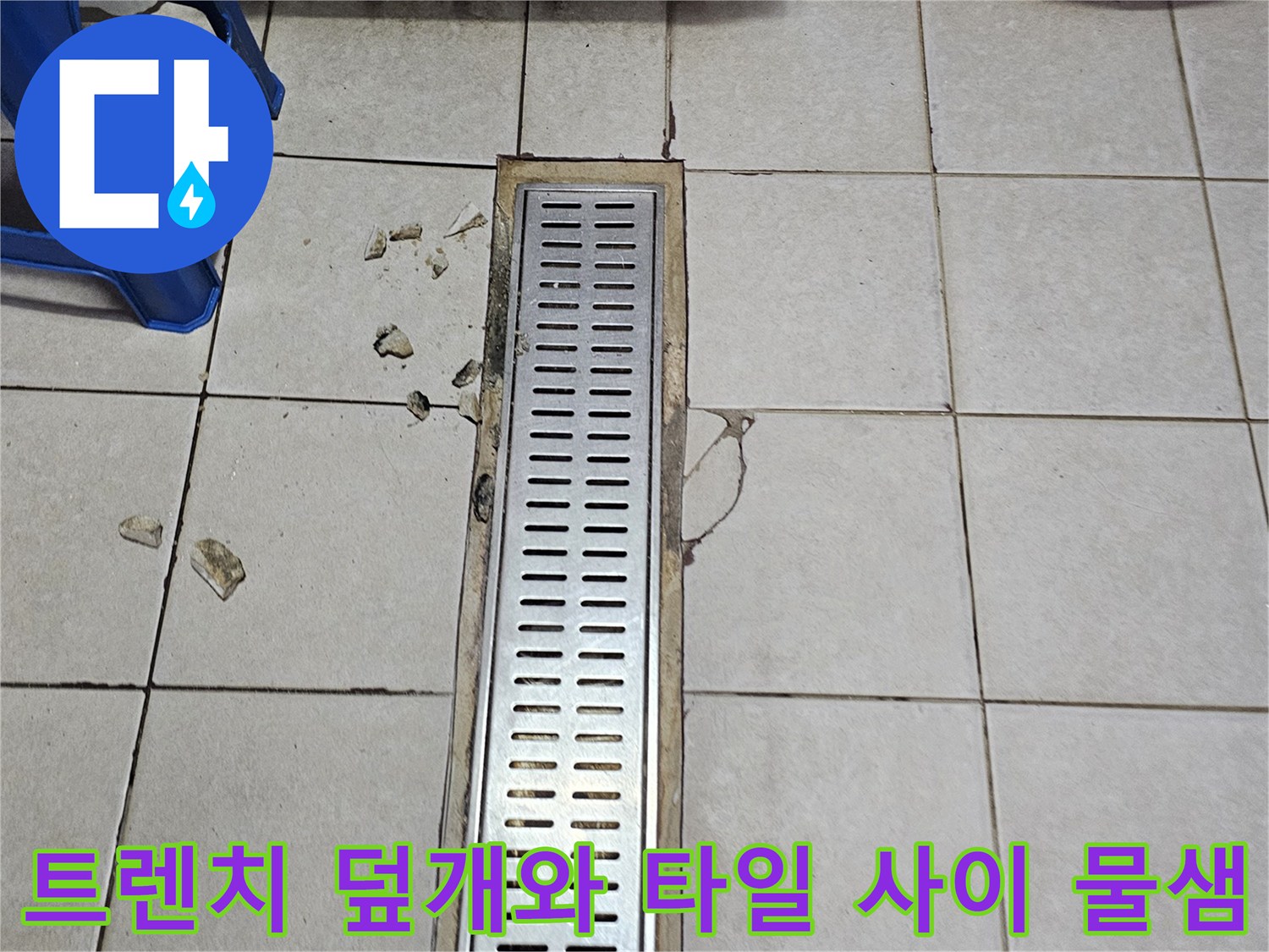 배수 트렌치 주변의 노후된 타일과 습기 머금은 틈새