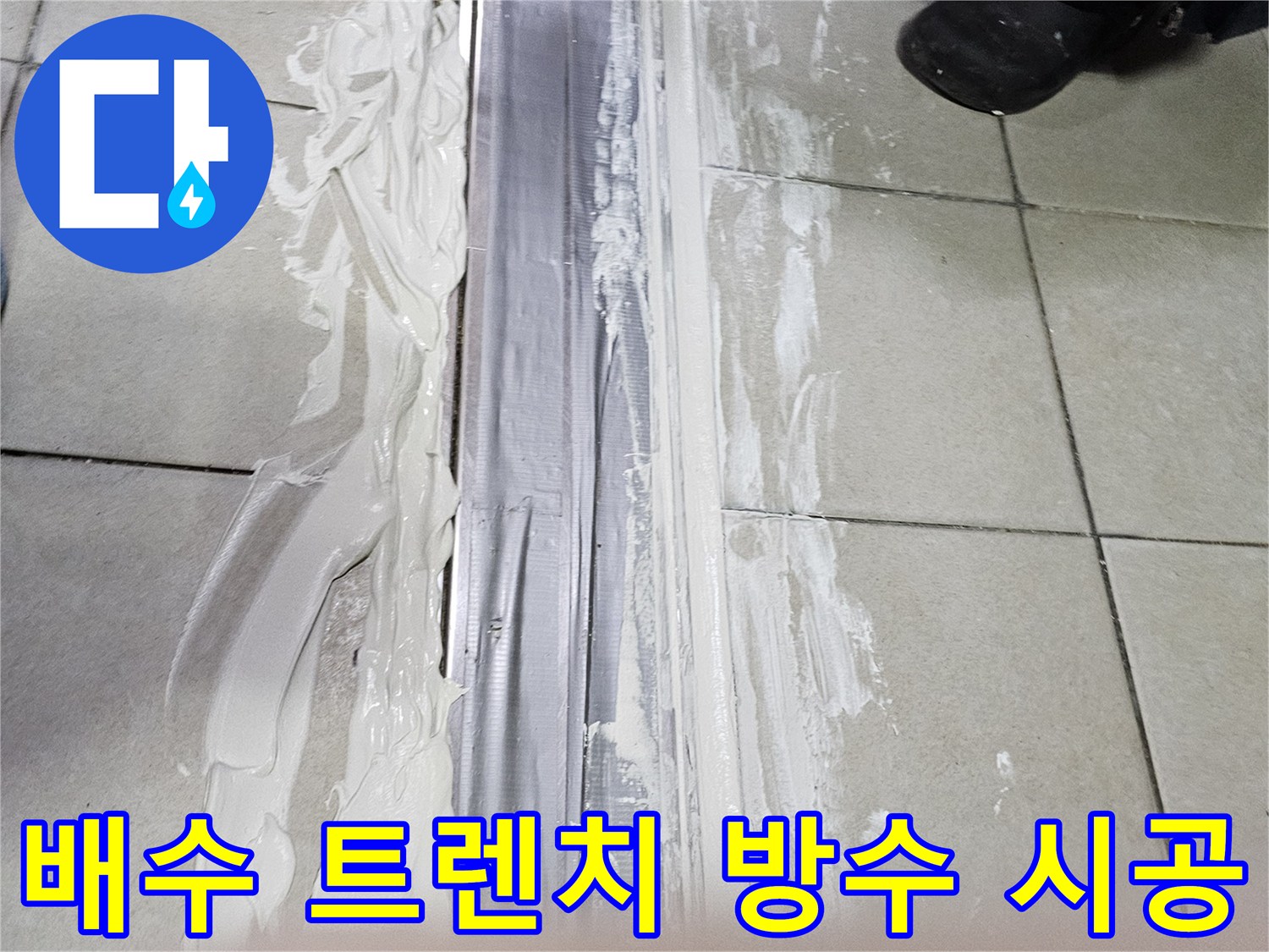 트렌치 덮개 주변에 하얀색 보수재를 도포하는 공사 현장