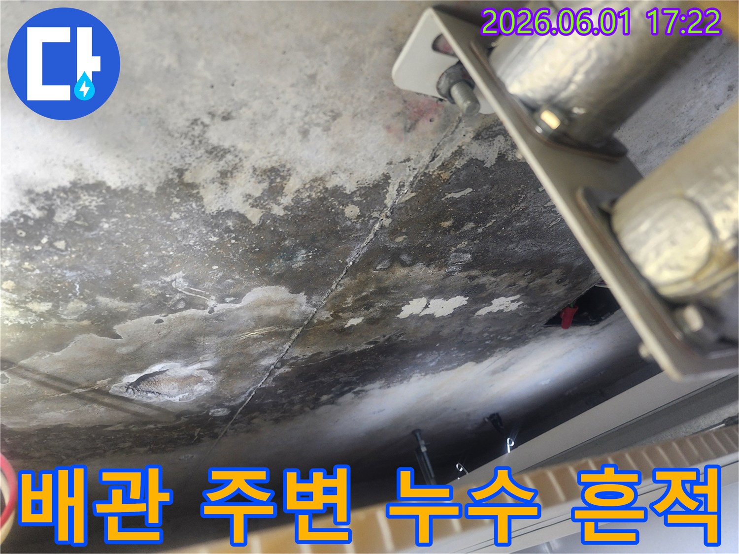 천장 콘크리트에 생긴 심한 누수 얼룩과 곰팡이-배관 고정 장치 주변으로 물이 스며든 흔적