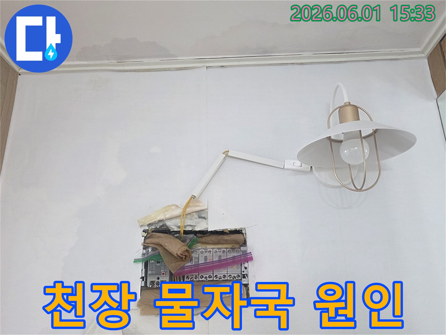 천장과 벽에 물자국이 선명하며-분전함 주변으로 물이 스며들어 전기 안전에 대한 우려가 큰 현장 모습입니다