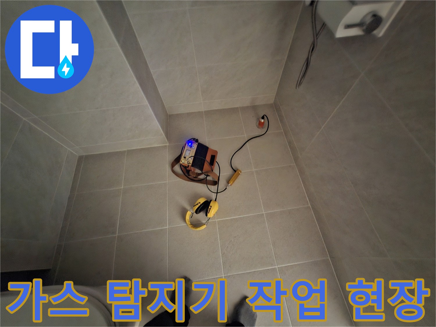 호텔 욕실 바닥에서 가스 탐지기를 사용하여 누수 지점을 찾는 모습입니다.