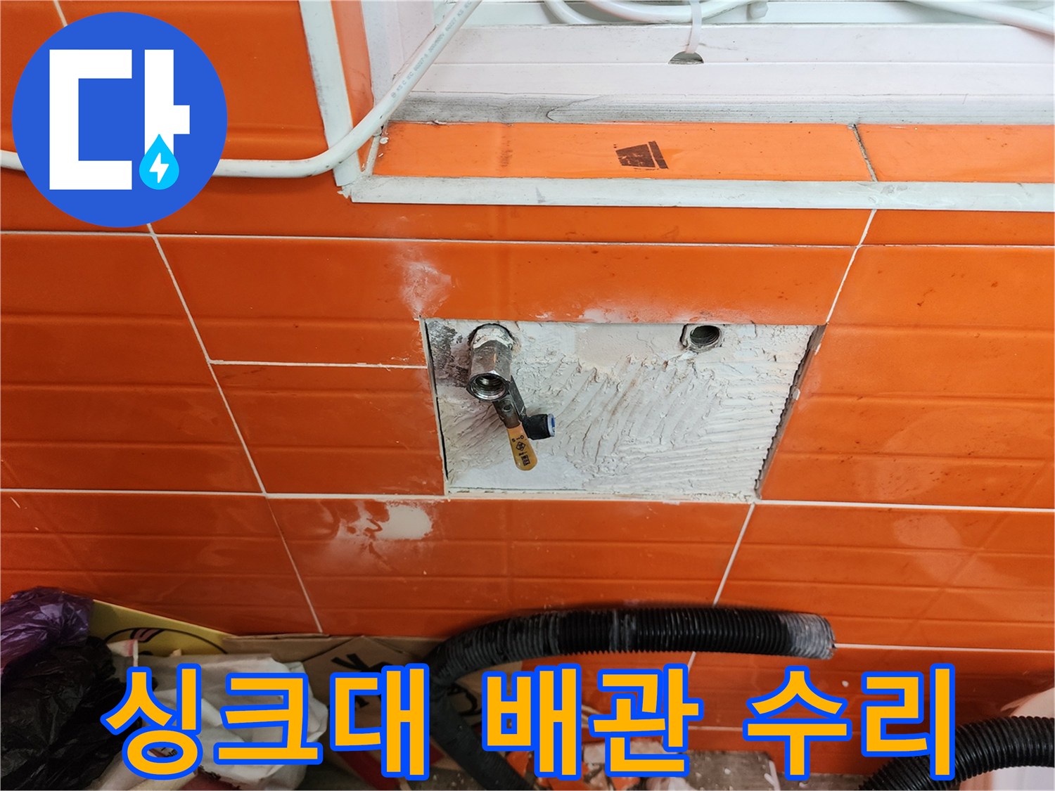 싱크대 아래 벽면의-타일을 제거하고-누수된 수도 배관을-수리하는 작업 현장