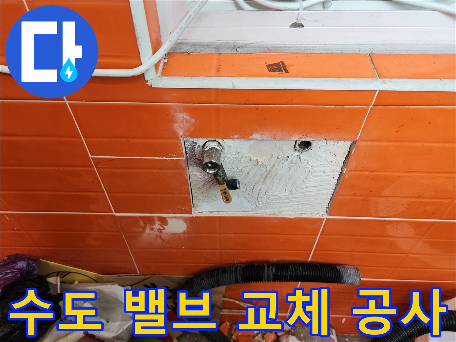오렌지색 타일 벽면의-노후된 수도 밸브를-새로운 것으로 교체하는-수도 배관 공사 현장