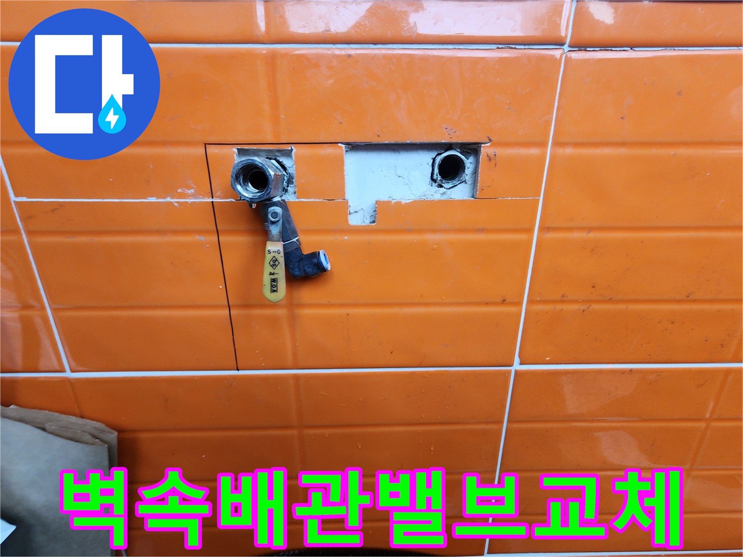 오렌지색-타일이-부분적으로-제거된-곳에-새로운-수도-밸브가-설치된-배관-수리-과정을-담은-사진입니다.