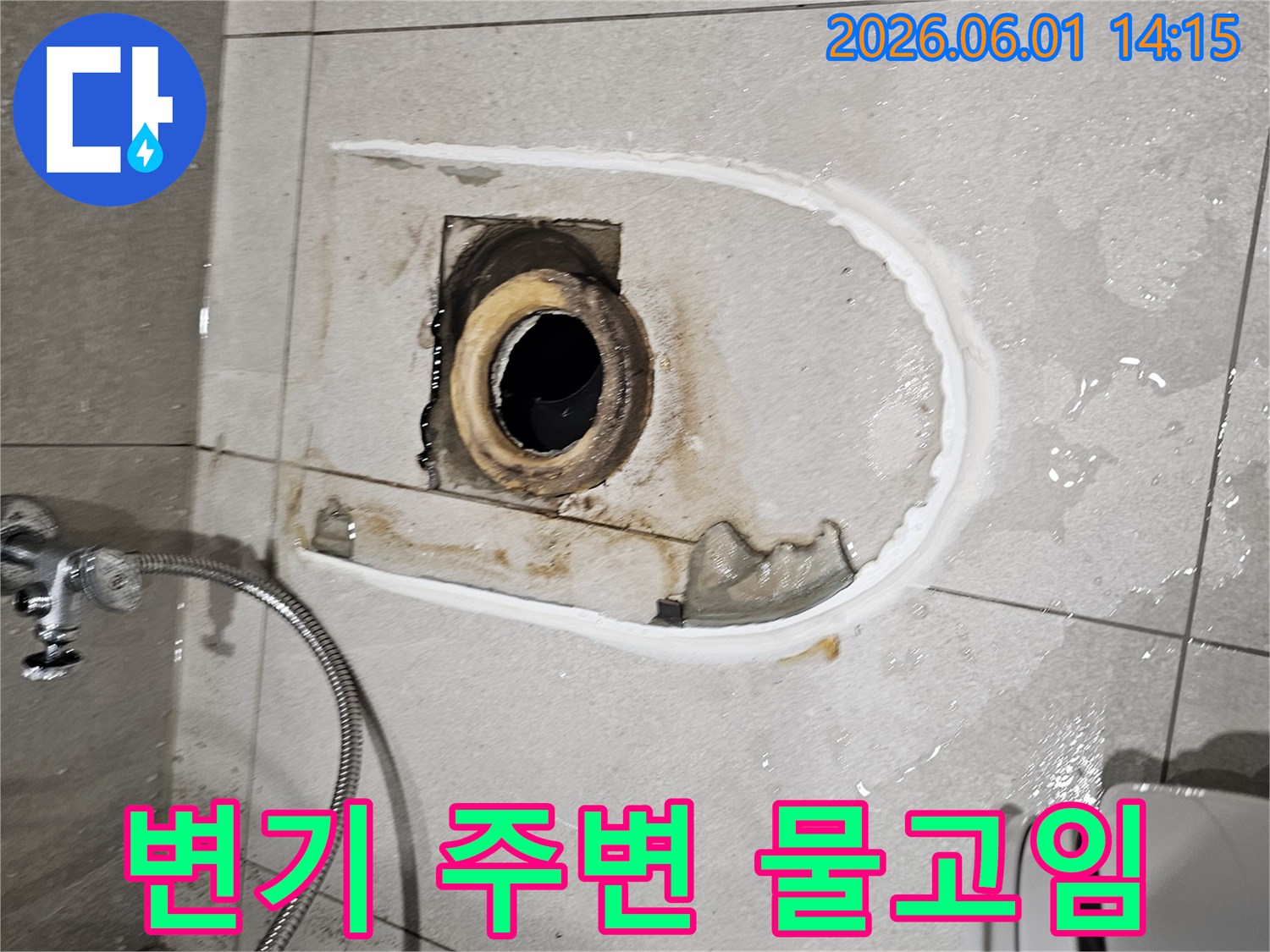 변기를 들어낸 자리에서-배관 주변에 물이 고여있는 누수 현장을 보여주는 사진입니다