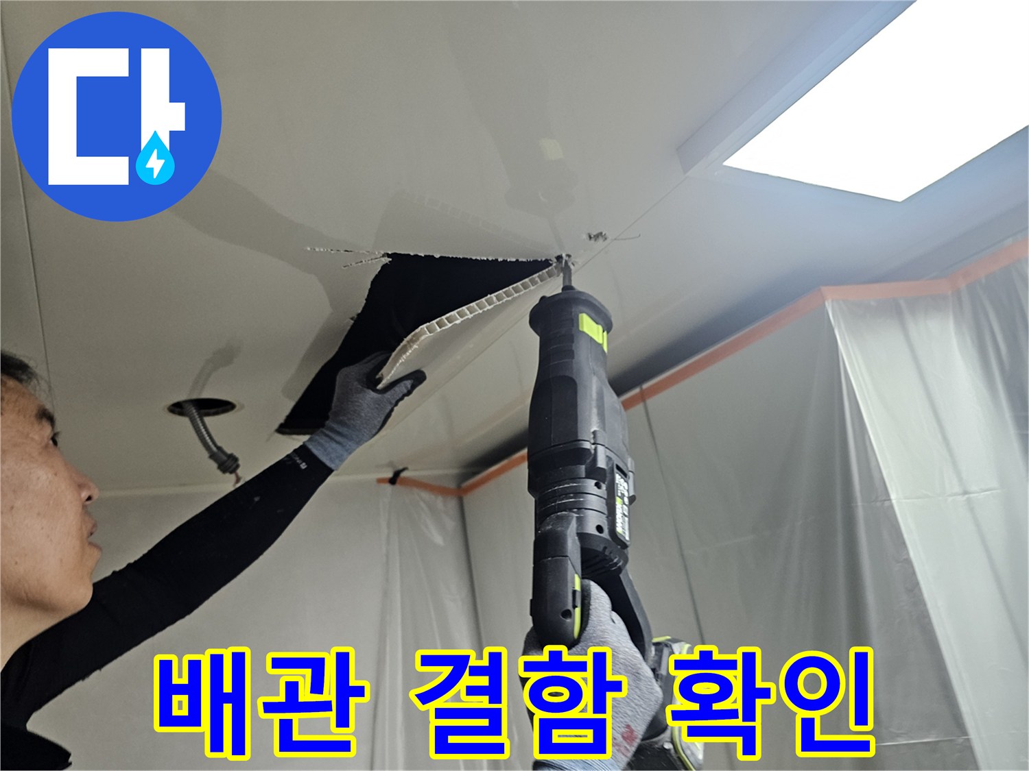 천장 내부의 배관 연결 부위를 꼼꼼하게 점검하고 있는 장면입니다.