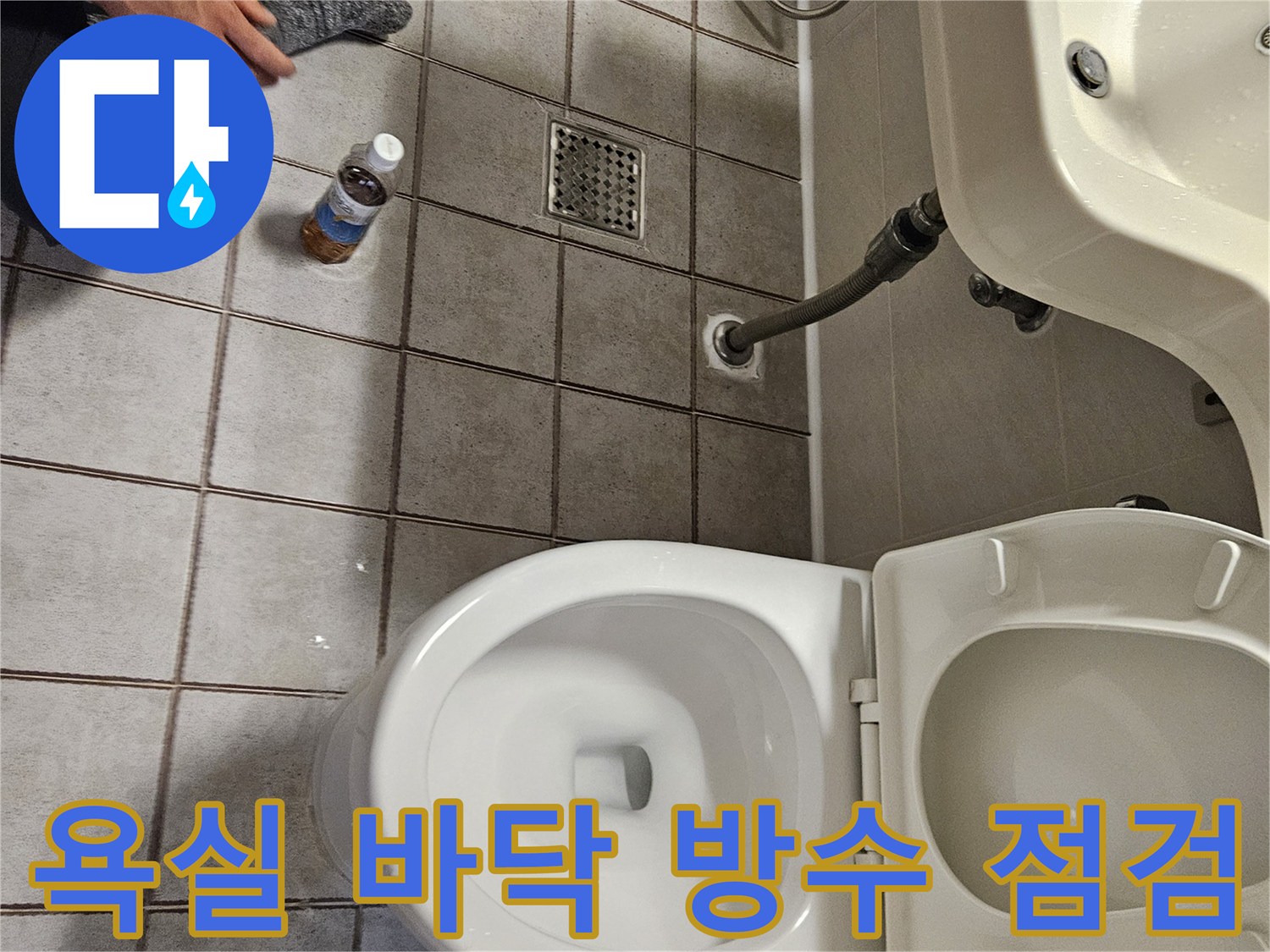 화장실 타일 바닥의 배수구와 변기 주변 상태를 근접 촬영한 사진