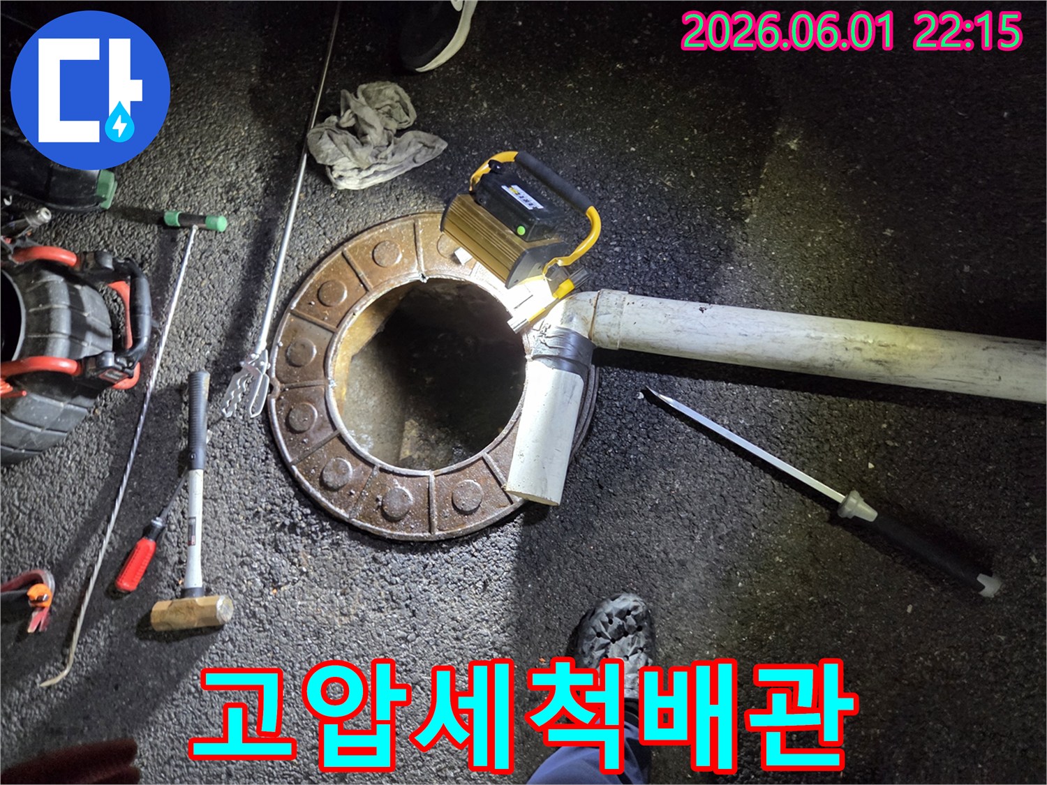 파쇄된-맨홀-주변에서-배관-청소를-진행하는-숙련된-기술자