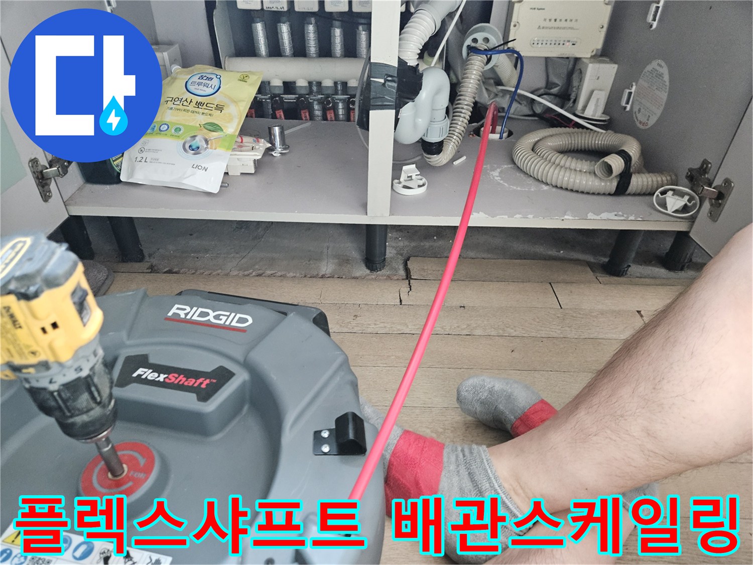 싱크대 하부장 내부-플렉스샤프트 장비를 이용한 배관 세척 작업 중