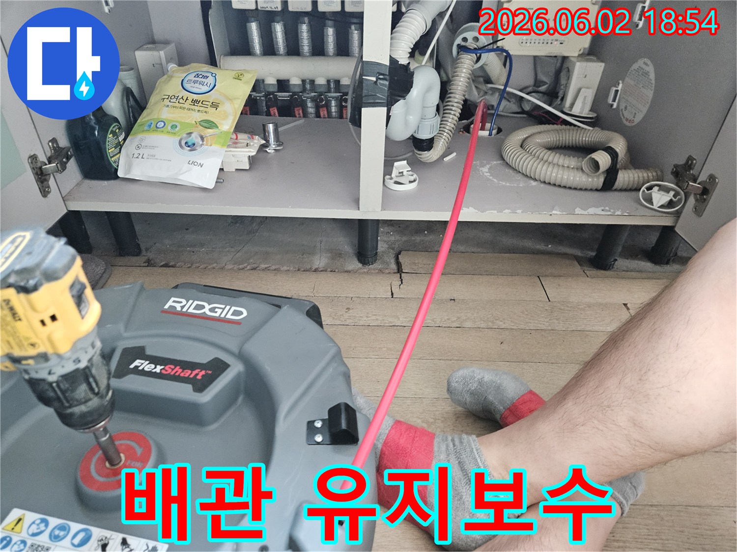 주방 싱크대 아래-배관 막힘을-해결하기 위해-전문 장비를-설치하고-작업을 시작하는 모습입니다.
