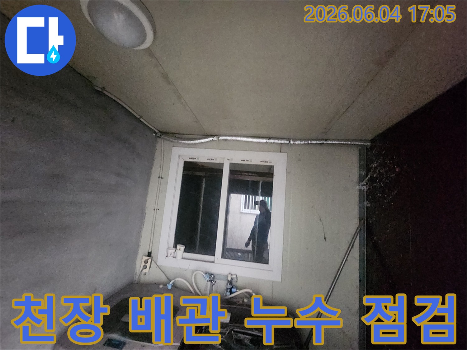 누수-엔지니어가-천장에-노출된-배관과-전선관-주변을-살피며-누수-가능성을-진단하는-모습
