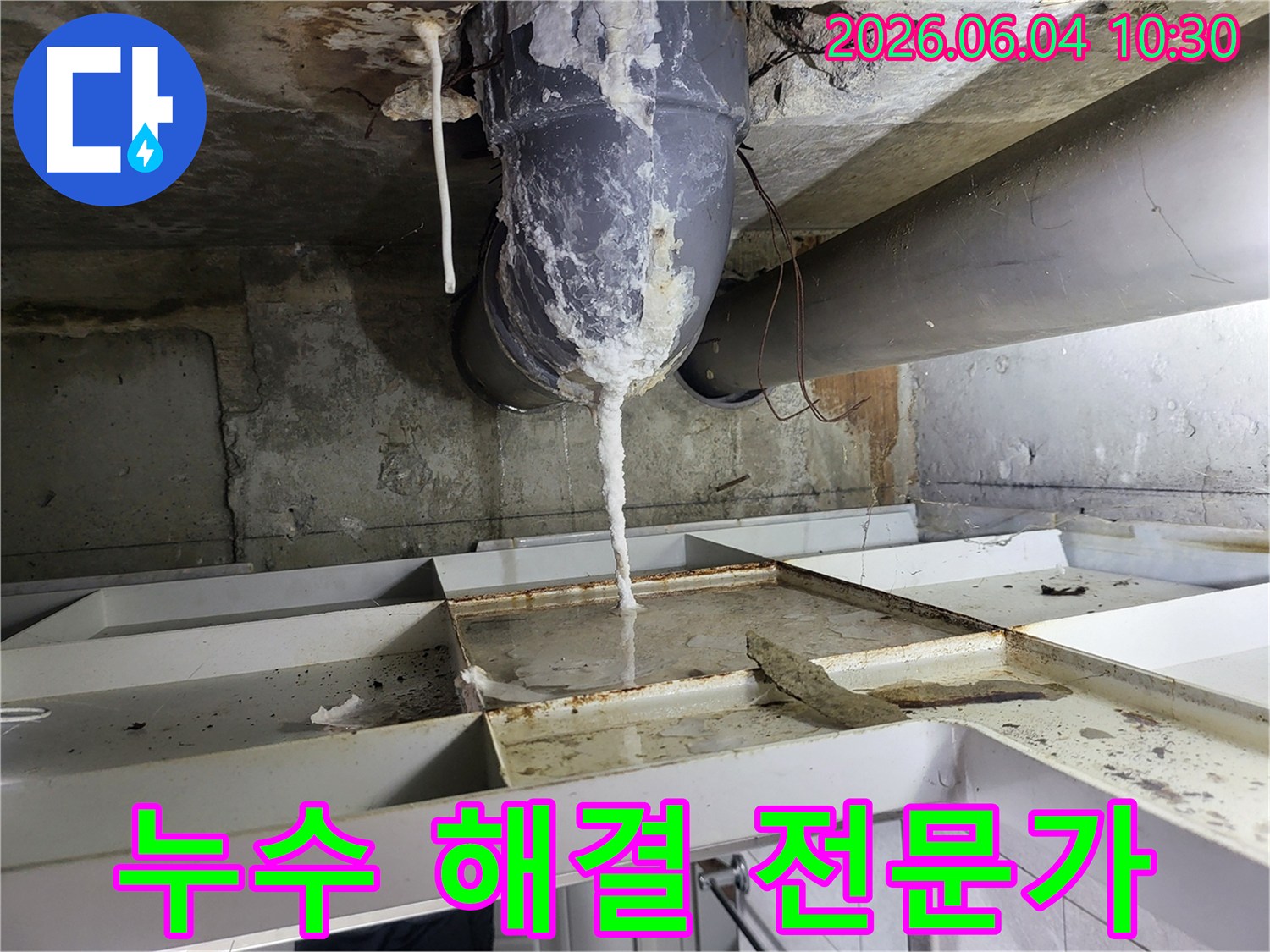 천장 배관에서 물이 새어 나와-석회질이 고드름처럼 맺히고-아래 바닥에 물이 고인 누수 현장