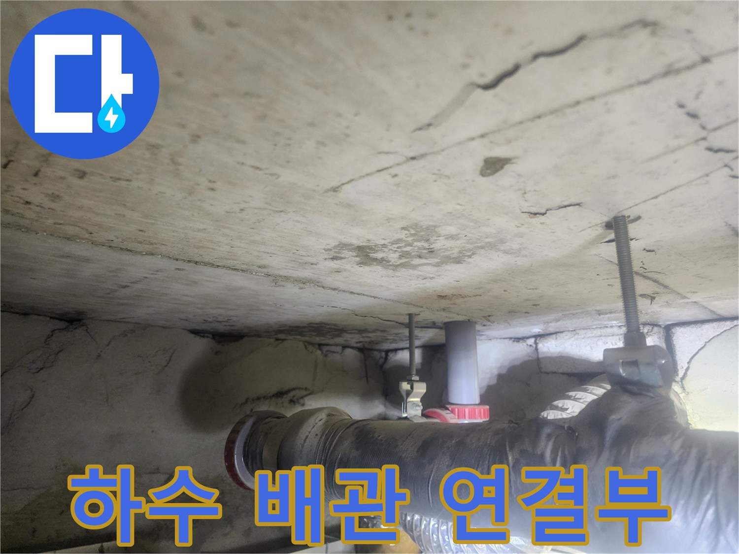 천장-아래-설치된-하수-배관의-연결-부위에서-누수가-발생하고-있는-모습을-보여주는-사진입니다