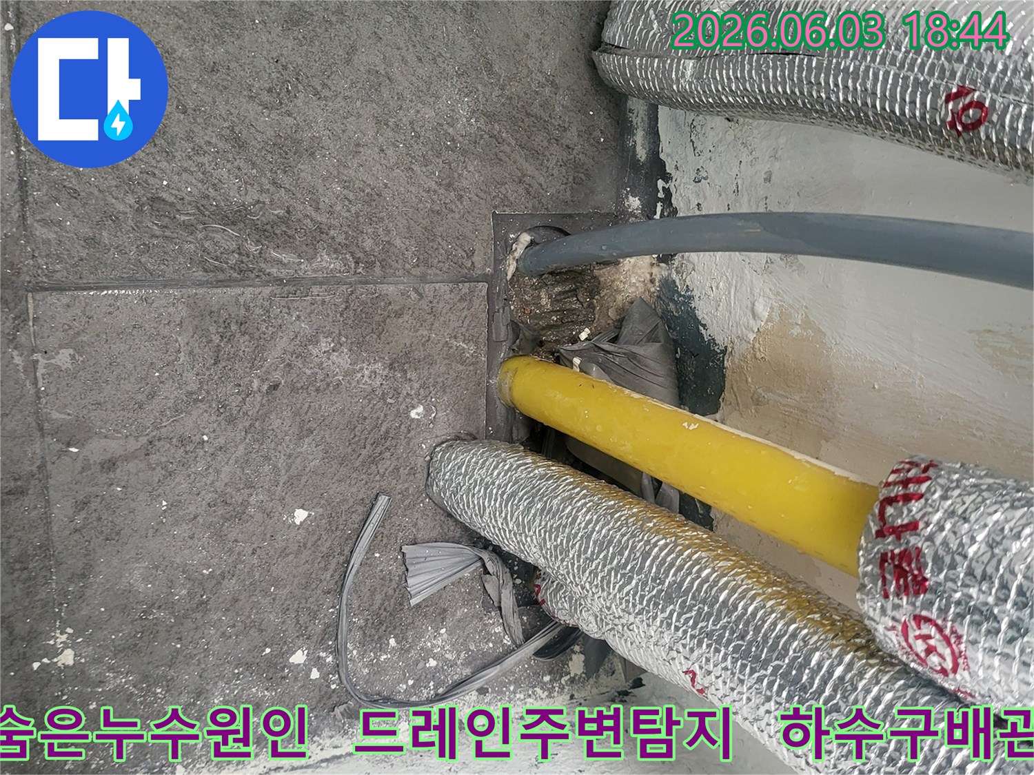 진말동 바닥 누수 현장에서-정밀 탐지를 통해-숨겨진 누수 원인을 찾기 위해-촬영된 배관과 드레인 부근의 사진입니다