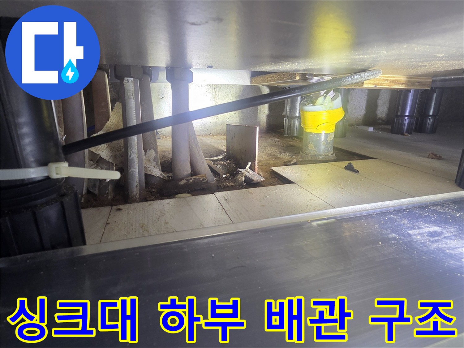 누수 확인을 위해 점검 중인 싱크대 밑 배관 연결 부위