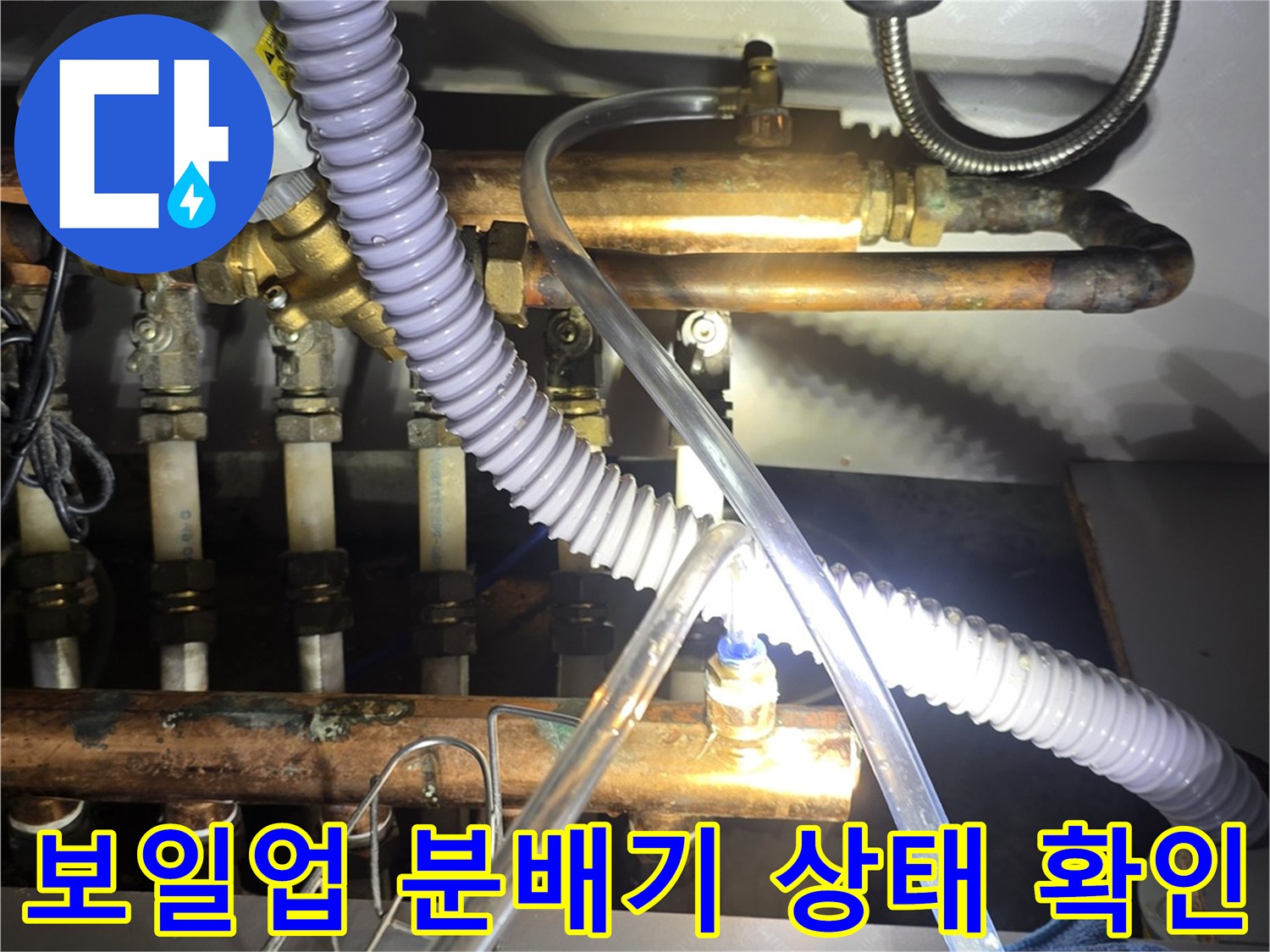 보일러 분배기와 연결된 다양한 배관들의 노후 상태를 보여주는 사진입니다.