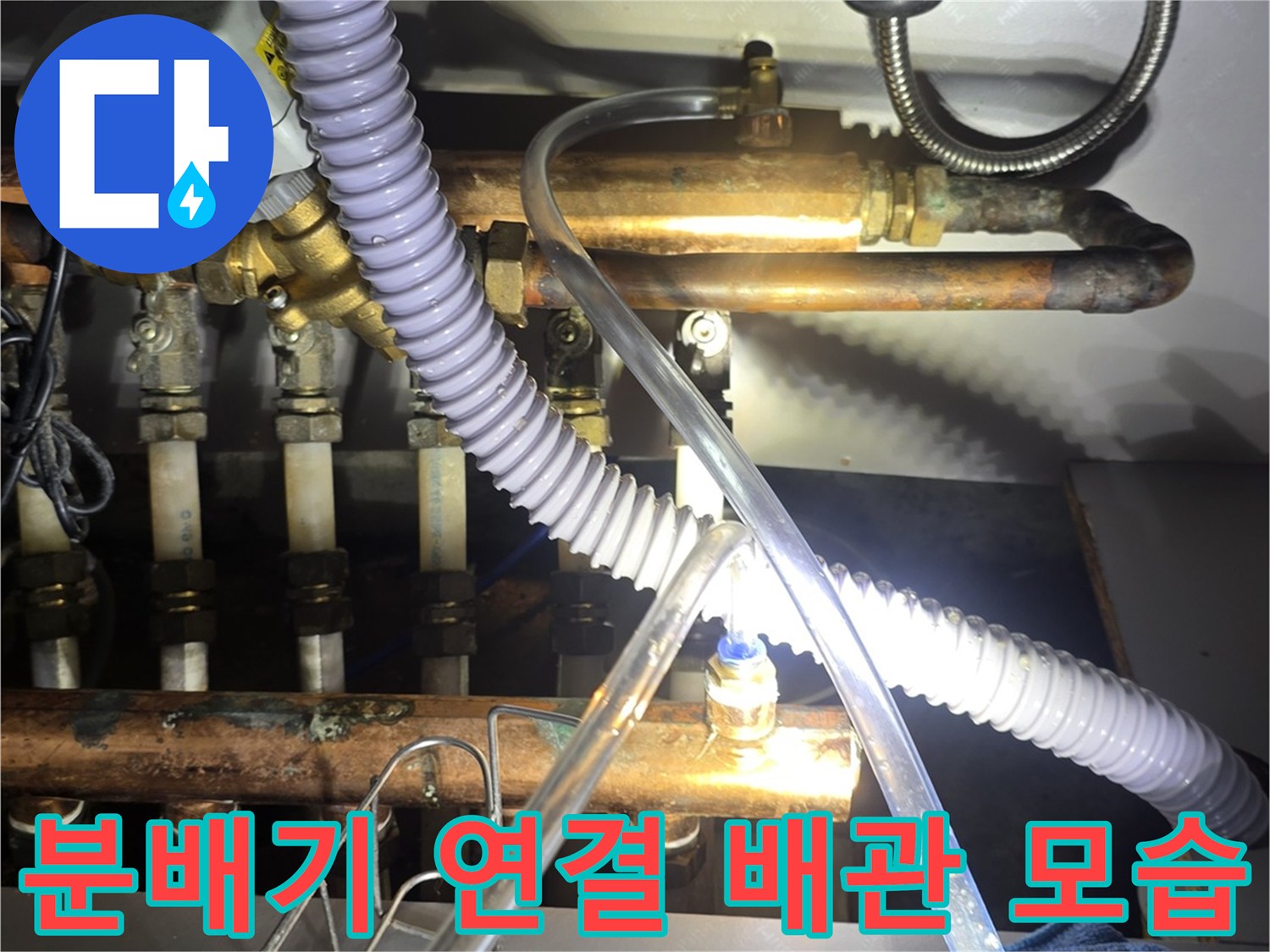 싱크대 하단부에 설치된 보일러 분배기와 유연한 호스 연결 상태