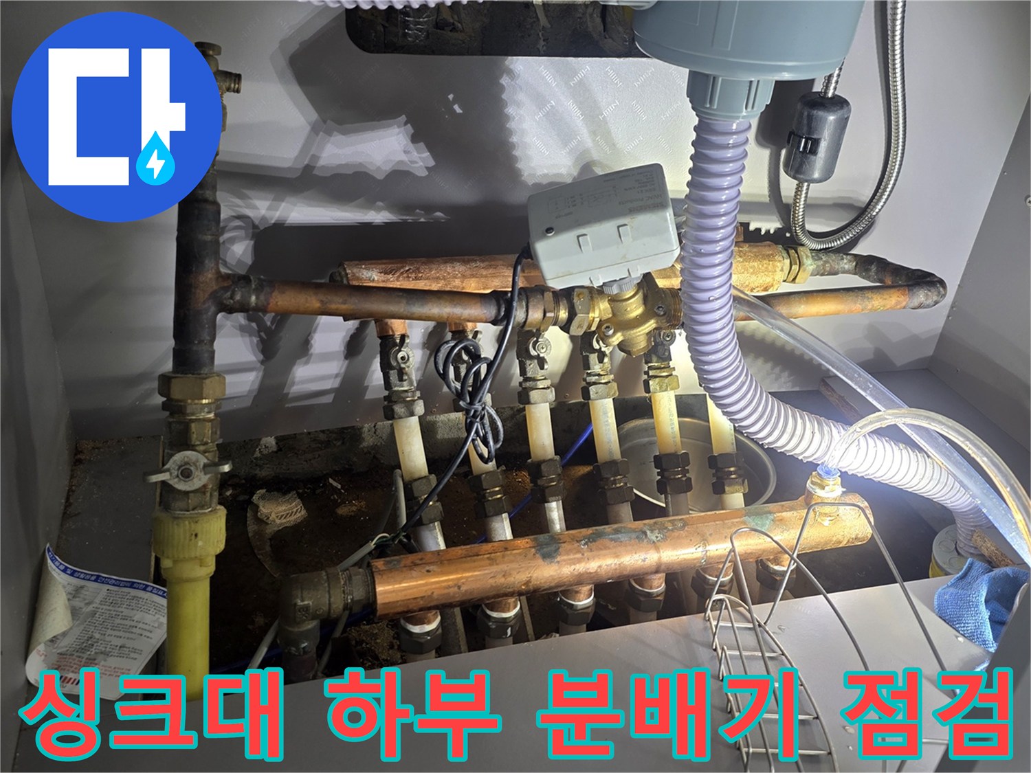 인천 연수구 아파트 싱크대 아래 분배기와 연결된 배관 상태를 확인하는 모습