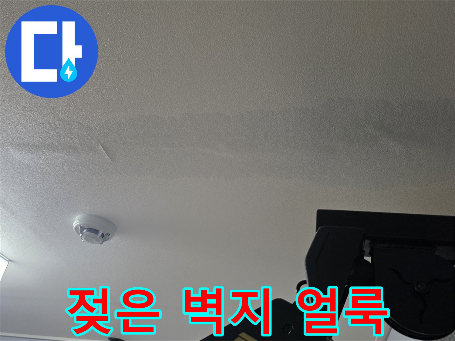 천장 벽지가 습기로 인해 변색되고 얼룩진 모습