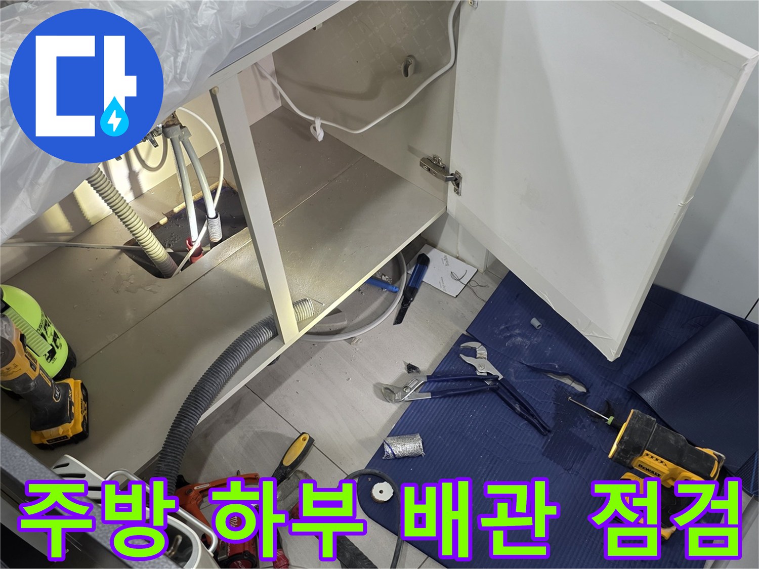 싱크대 아래쪽 배관 연결 부위와 작업용 드릴