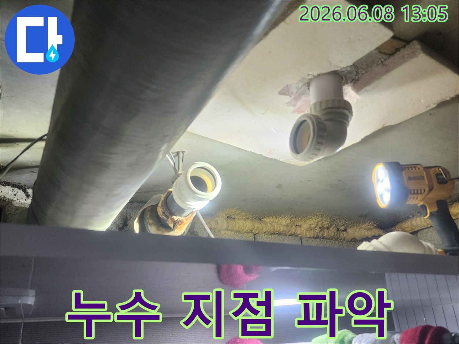 누수-전문가가-어두운-천장-속에서-강력한-조명을-활용하여-정확한-누수-지점을-찾아내는-모습
