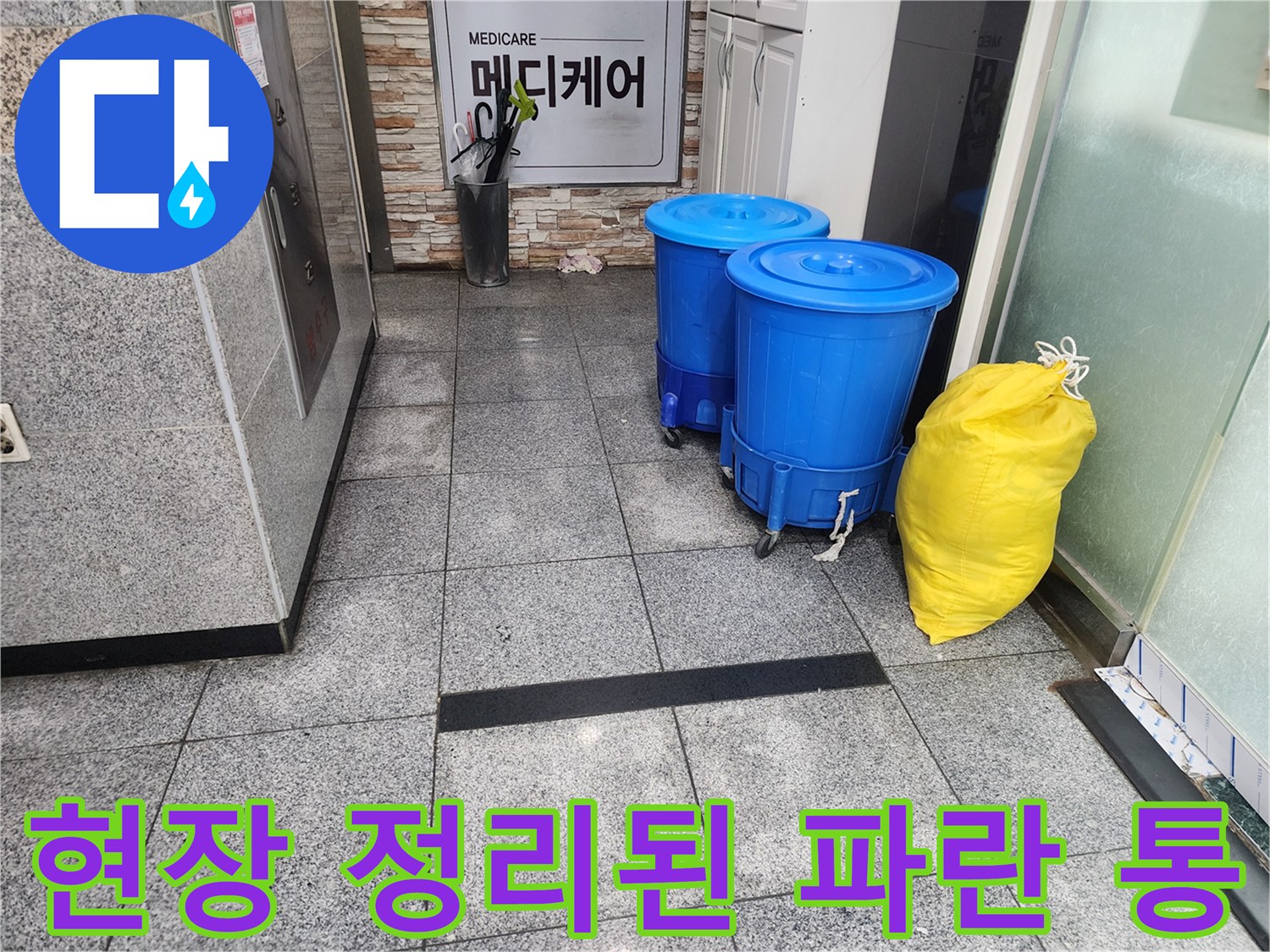 상가 내부 복도-작업 완료 후 정리된 파란색 용기와 봉투