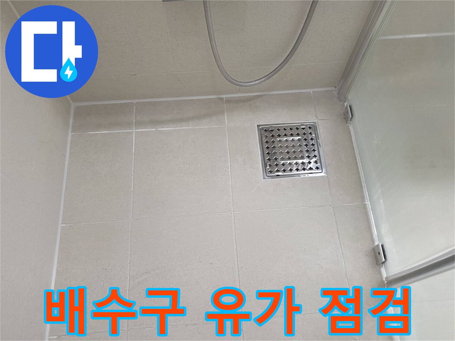 스테인리스 재질의 욕실 배수구와 베이지색 타일