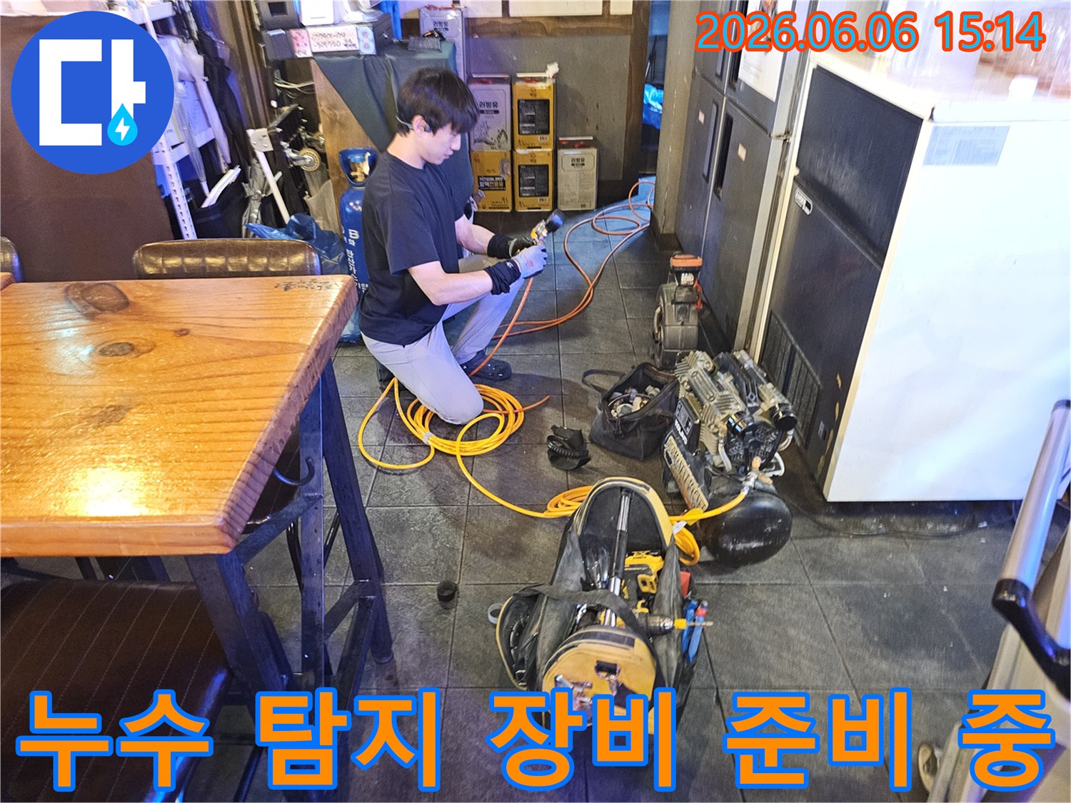 전문 엔지니어가-아파트 누수 해결을 위해-탐지 장비를 연결하고 있습니다.